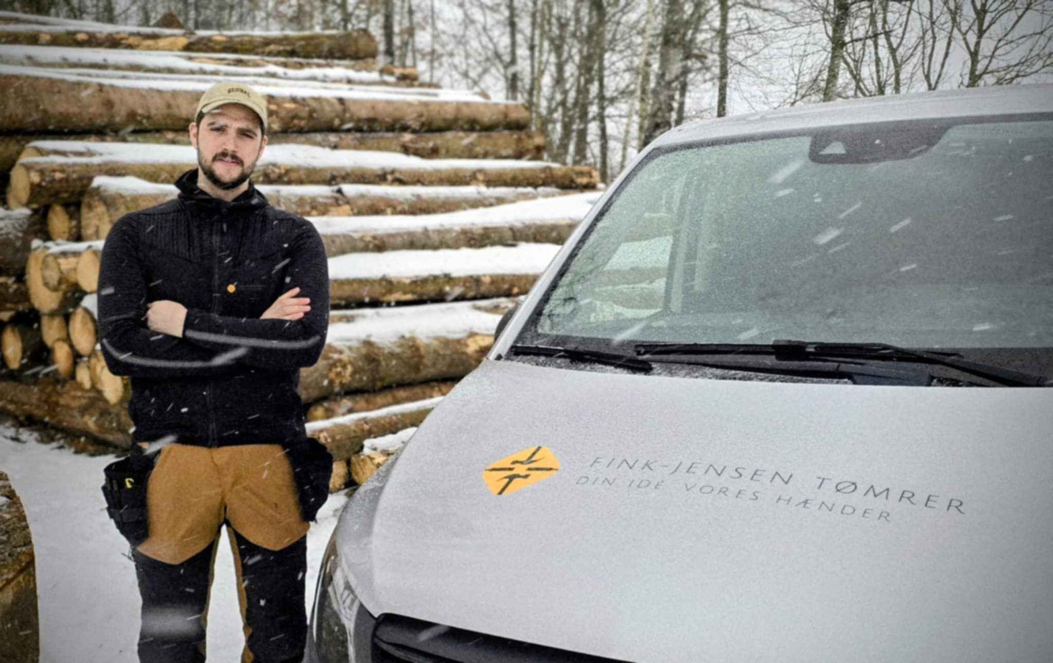 Tømrer Nikolaj foran sin firma bil.